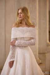 O femeie cu părul lung și blond poartă rochia de mireasă Eden Bride Rochie de mireasă V-1251, cu dantelă fină și mâneci lungi detașabile, stând în fața unor coloane de piatră și privind în lateral. Numărul 1251 apare în colț. Rochii de mireasa Eden Bride